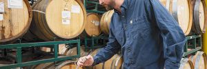 Dustin Andries, head winemaker at Naumes Crush and Fermentation, sampling wine in a barrel. ##Photo by Karen Adair
