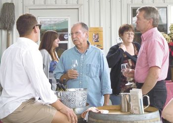 Sam talks with guests at a summertime Amity DIG event. Photo provided.