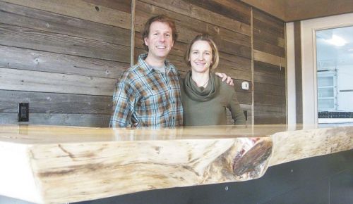 Steve Thompson and his wife, Kris Fade, behind the 100-year-old Ponderosa pine slab that anchors the interior of their tasting room featuring Analemma Wines.