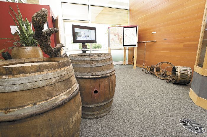 French oak barrels and an antique wine press are part of Linfield College’s Oregon wine history exhibit, “Bringing Vines to the Valley.” Photo by Marcus Larson.