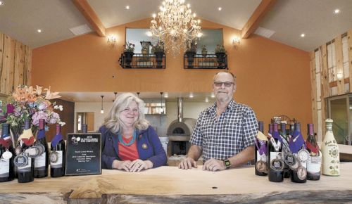 Patrik and Tess Barr stand behind the bar made from timber gathered from their Hood River property. ##Photo provided by Hood Crest
