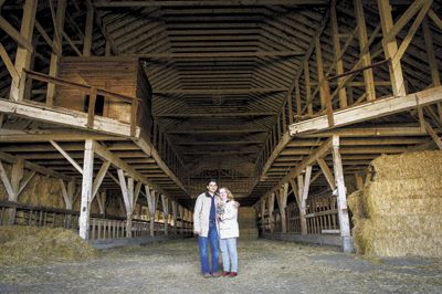 Sanjeev Lahoti and Angela Summers stand inside the huge dairy barn, which has now been dismantled for reuse in their new tasting room.