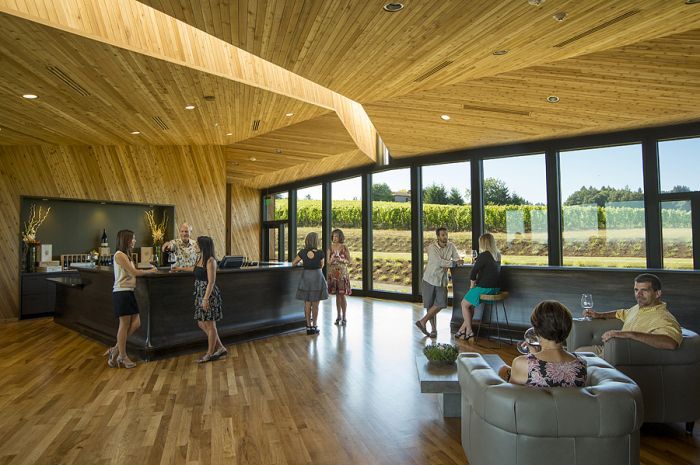 Inside the tasting room, guests mingle by the bar and in leather lounge chairs. Photo by Andrea Johnson.