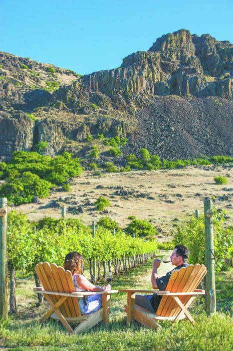 A couple relaxes with wine at Cascade Cliffs Winery’s estate vineyard outside The Dalles in Wishram, Wash. Photo by Andrea Johnson.